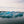 Icebergs floating in a body of water with a cloudy sky.